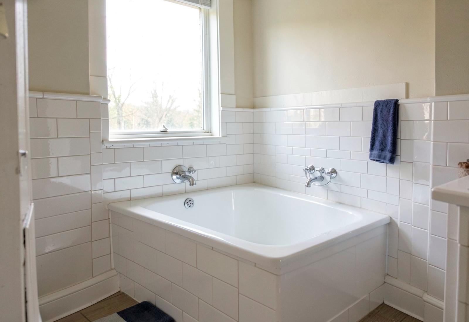 Refinished white alcove bathtub in a clean tiled Ann Arbor area bathroom